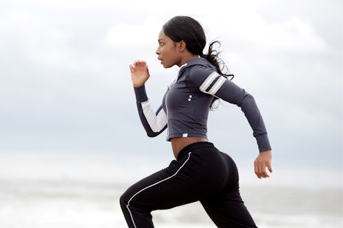 Side portrait of sporty young black woman running