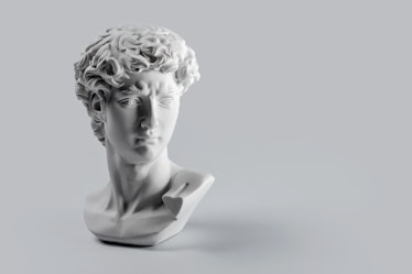 Gypsum statue of David's head. Michelangelo's David statue plaster copy on grey background with copy...