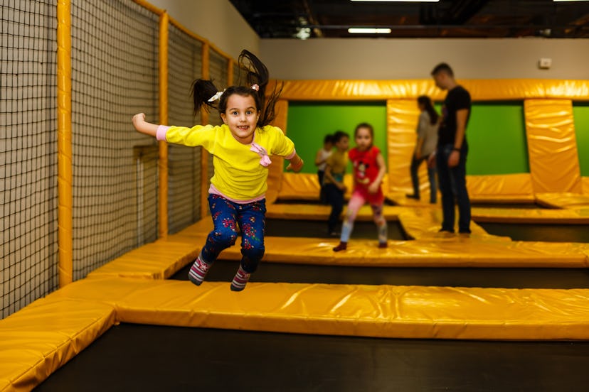 Children playing in a well-padded room on multiple trampolines