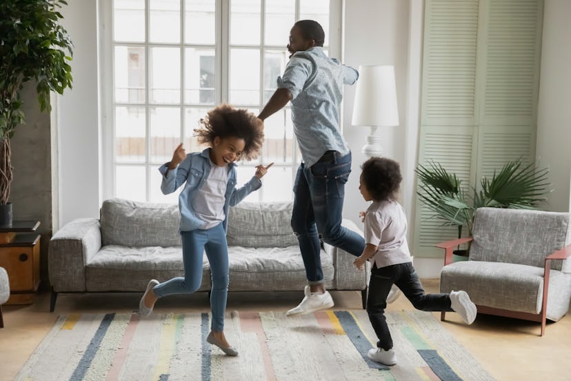 A dad and his two kids having a dance party in the living room in a round up of baby's first thanksg...