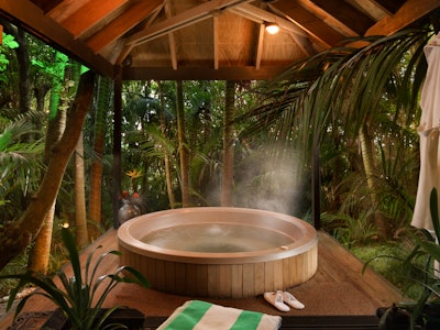 A hot tub under a pagoda sitting in the palm forest