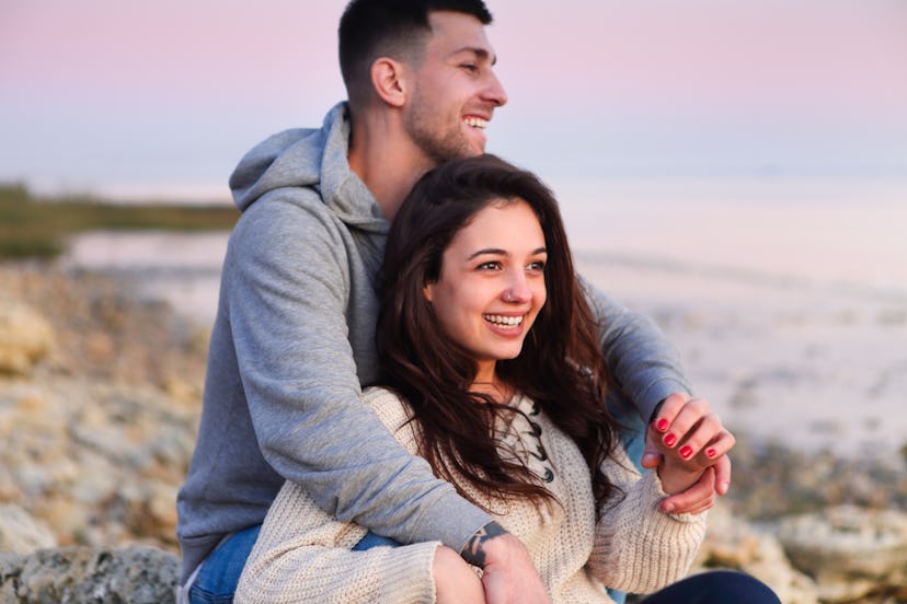 Young couple hugging and laying on the beach