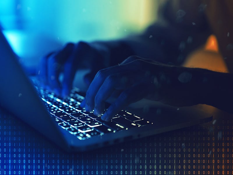 Hacking concept. Hacker using abstract laptop with binary code digital interface. Blue and orange th...