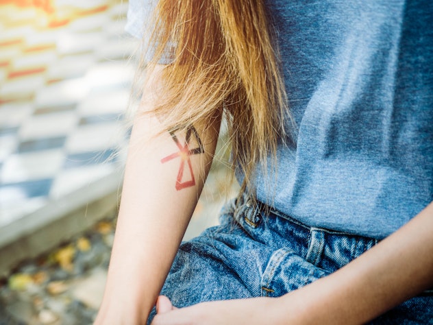 a woman' s arm with a small tattoo