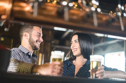 Young couple at beginnings of love story - Pretty woman drinking beer with handsome man at pub - Rel...