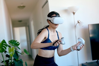Young woman doing VR kickboxing at home with an Oculus Quest 2
