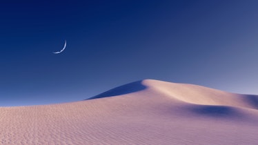 Fantastic unreal sandy desert landscape with massive sand dunes and half moon in clear night sky. Wi...