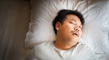 Asian man sleeping on bed with snore face.Concept of snoring.Healthcare medical.Sleep health.Indian ...