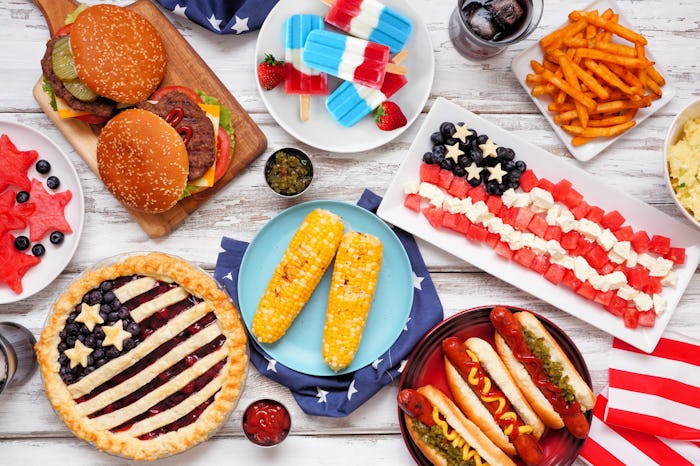 bbq food like burgers, hot dogs, and pies on a table