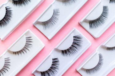 Different false eyelashes on a trendy pastel pink background. Beauty pop art pattern. Makeup accesso...