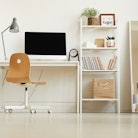 Low angle view at all-white modern interior with focus on empty home office workplace, copy space