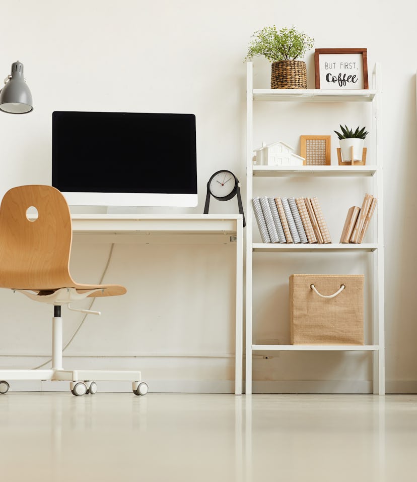 Low angle view at all-white modern interior with focus on empty home office workplace, copy space