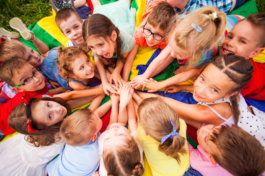 Top view kids in circle laying on colorful cloth