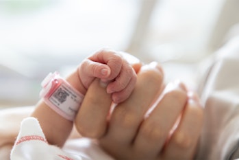 newborn baby hand holding mom's index finger