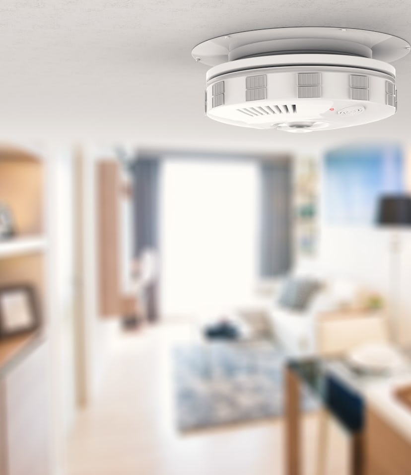 Close-up photo of a smoke alarm mounted on a home ceiling.