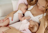 a mom using a tandem breastfeeding technique to breastfeed twin babies.