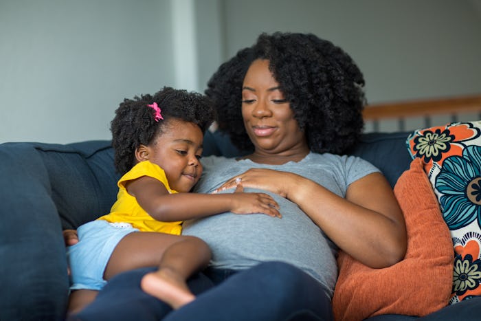 pregnant mom with toddler touching her belly