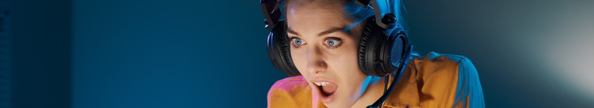 Shocked woman playing at night with her laptop, she loses the game and she is disappointed