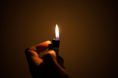 

light a fire with the lighter in darkness