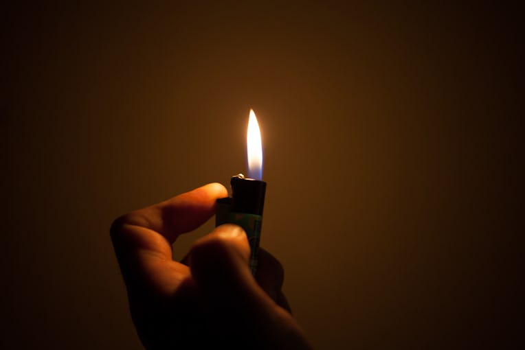light a fire with the lighter in darkness