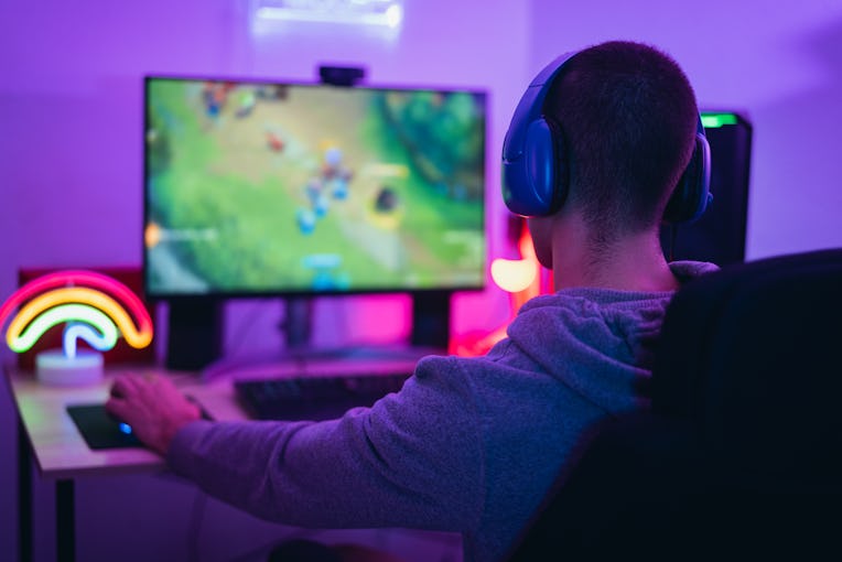 Young gamer playing online video games while streaming on social media - Youth people addicted to ne...