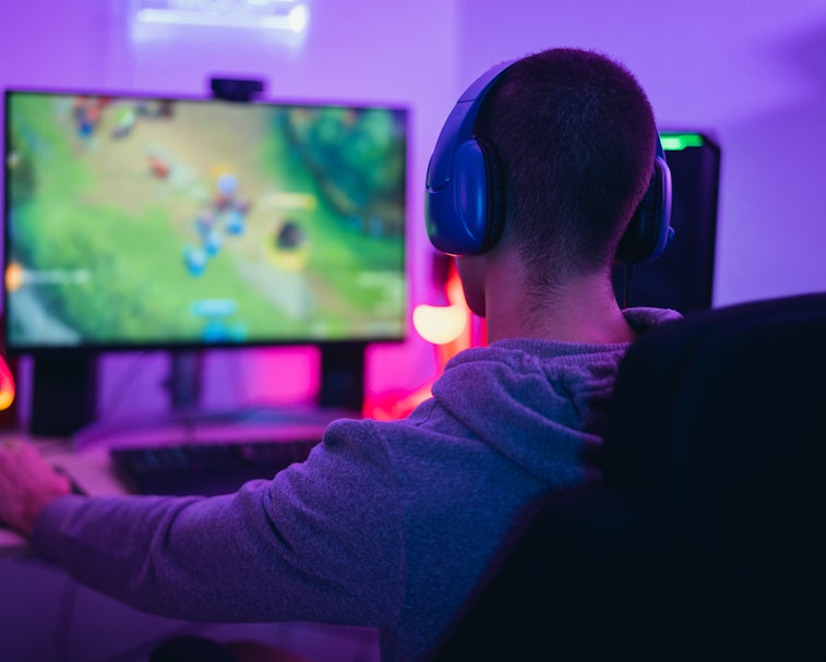 Young gamer playing online video games while streaming on social media - Youth people addicted to ne...