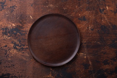 Empty plate and linen napkin on brown wooden background Copy space Top view - Image