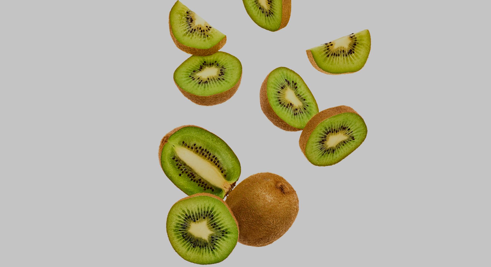 Fresh kiwi fruit flying in air on yellow. Fruity green color diet food. Summer whole, cut kiwi backg...