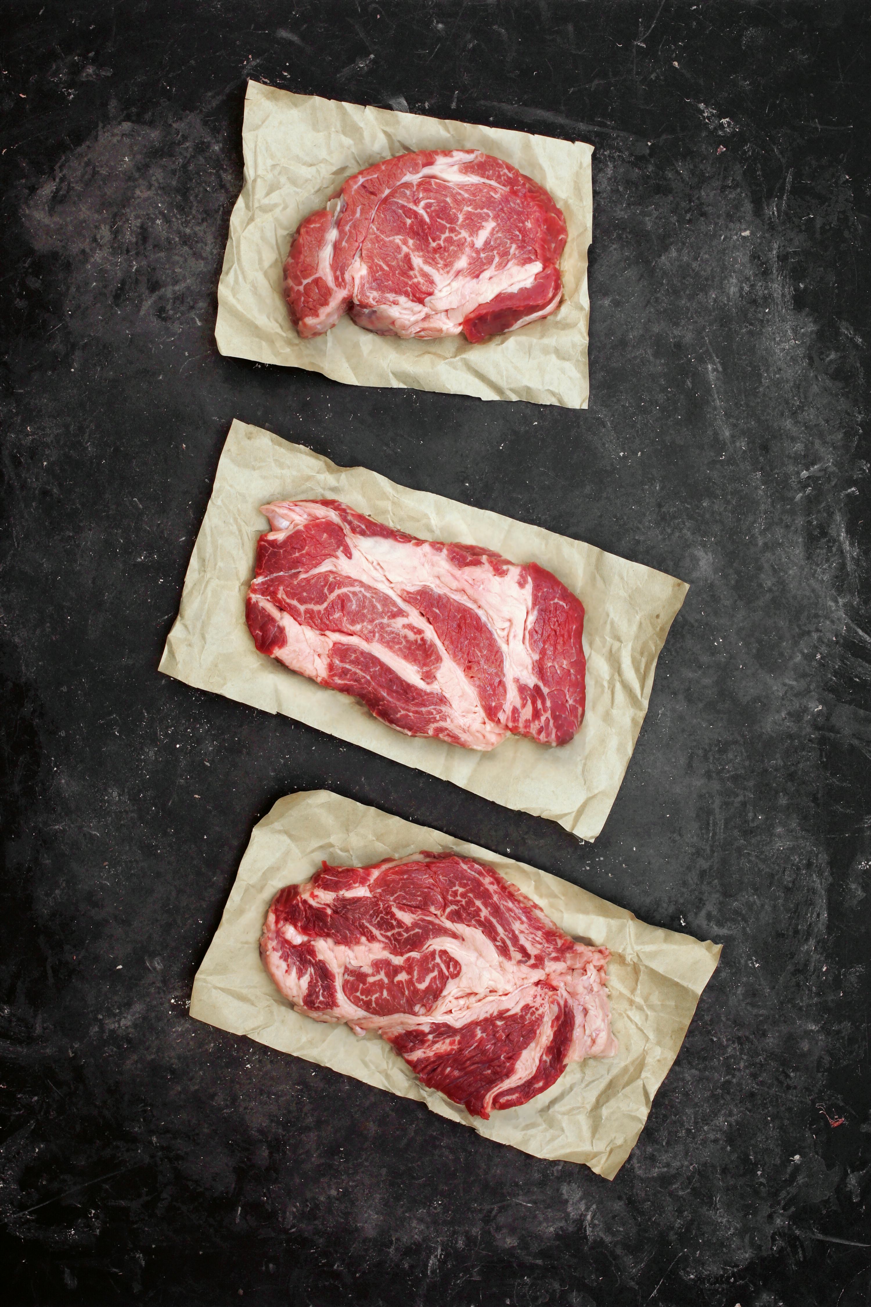 Raw Marbled Loin Beef Steaks On Brown Paper. Sirloin Beef Steaks, Overhead View. Three Raw Striploin...