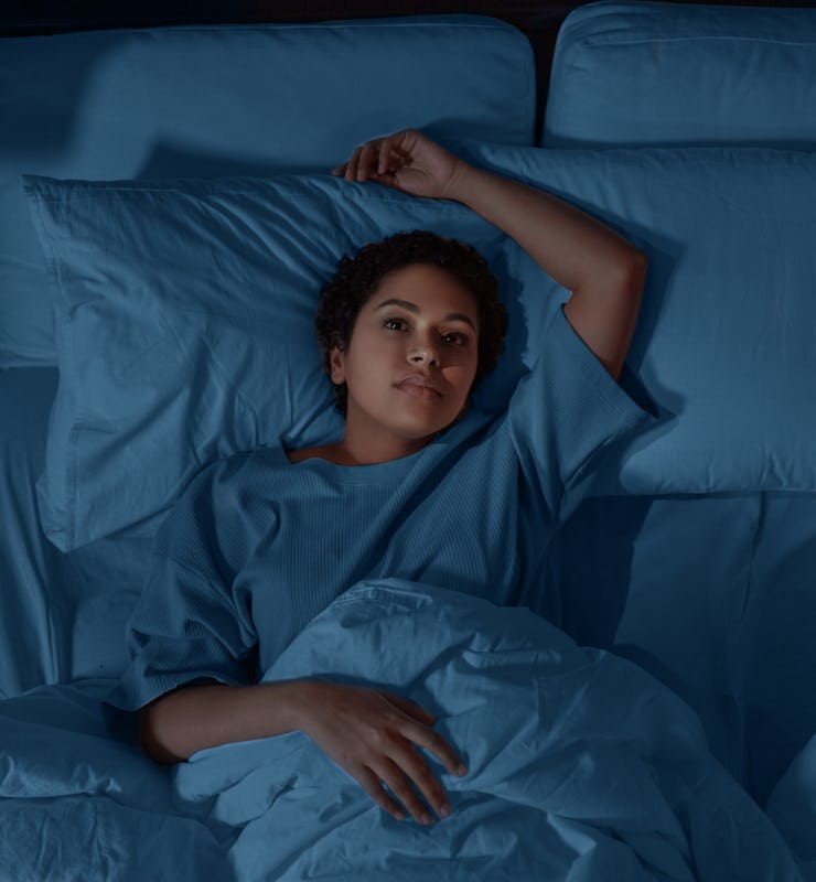 people, bedtime and rest concept - sleepless african american woman lying in bed at night