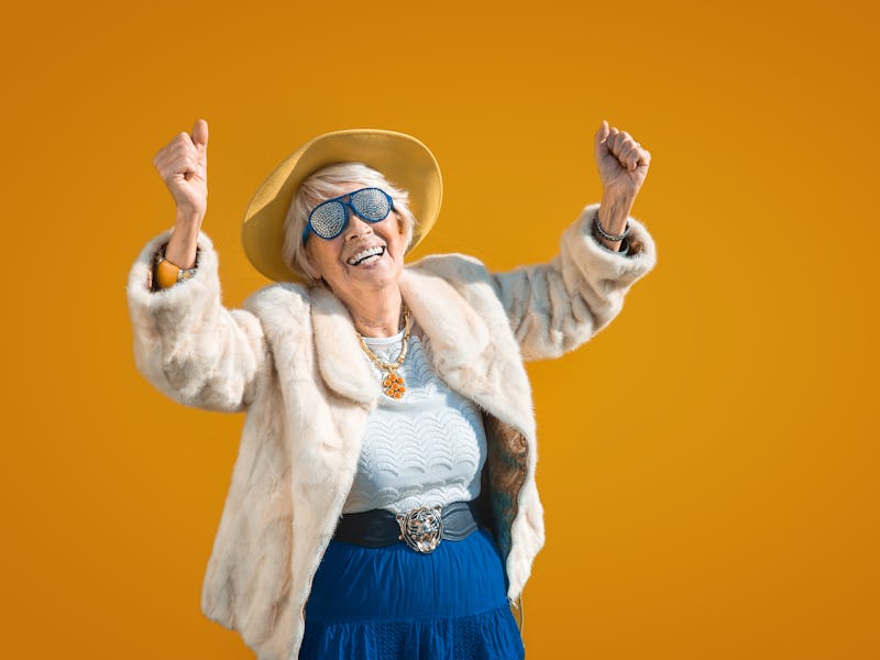 Happy and playful senior woman having fun - Portrait of a beautiful lady above 70 years old with sty...