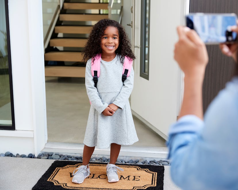 mom taking photo of her child on the first day of school