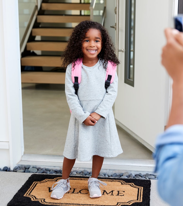mom taking photo of her child on the first day of school 
