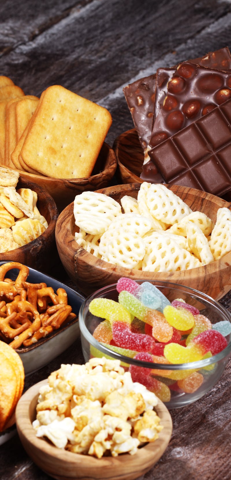 Salty snacks. Pretzels, chips, crackers in wooden bowls. Unhealthy products. food bad for figure, sk...
