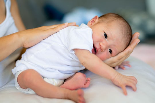 A mother taking care of her newborn baby, patting and burping after feeding.