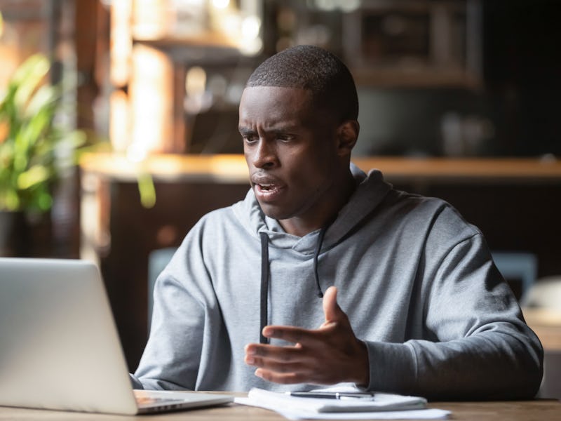 Frustrated black male student work at laptop get mad having device software operational problems, an...