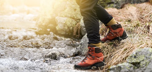 Adventure woman hiking in the mountain. View of hiking boots.