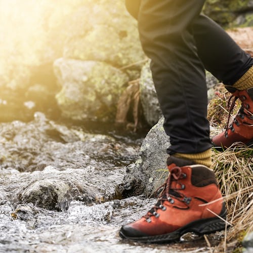 Adventure woman hiking in the mountain. View of hiking boots.