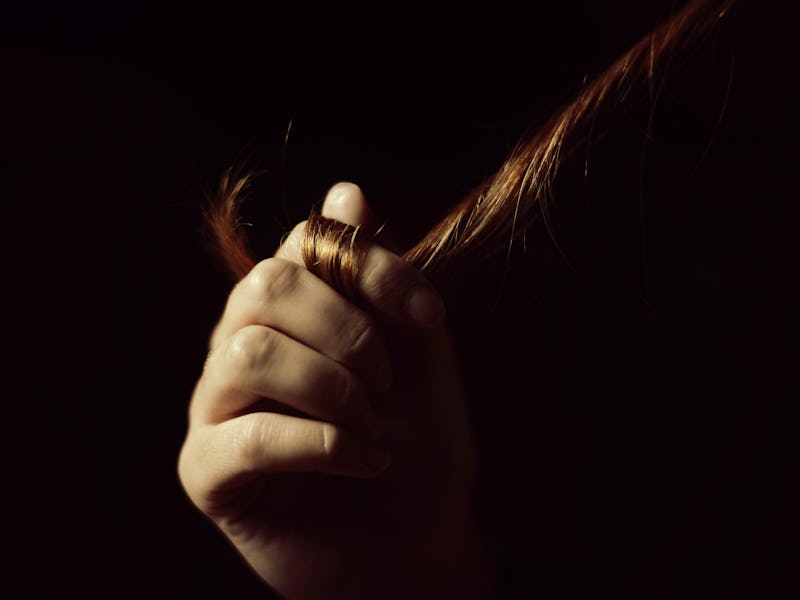 Woman twirling her long hair around her fingers 