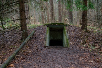 Entrance to underground military bunker in the forest.