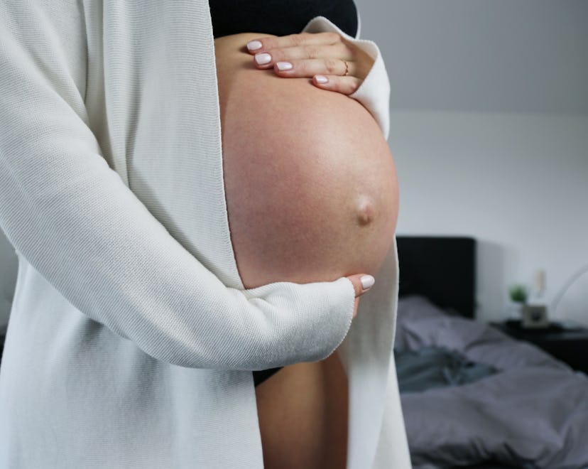 Pregnant woman with a big baby bump and bellybutton