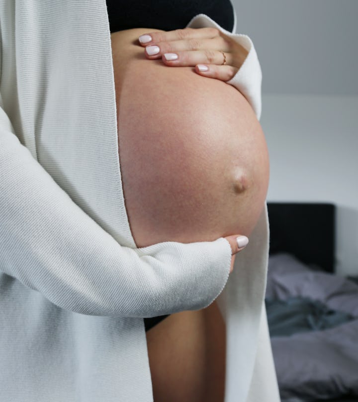 Pregnant woman with a big baby bump and bellybutton