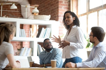 Ambitious smart african black female employee speaking at diverse meeting share creative idea opinio...