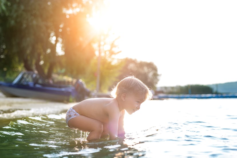 baby boy splashing in river