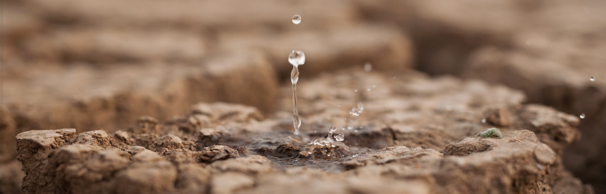 Water drop to dry cracked land metaphor lack of rain, water crisis, Climate change and Environmental...