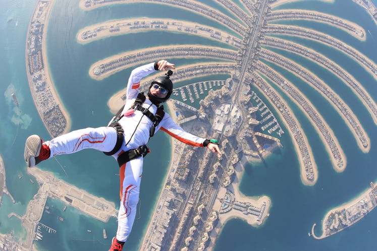 Dubai.People lies on beach Dubai Palm in free fall sky jump. Sea outdoor skydiving travel man. Free ...