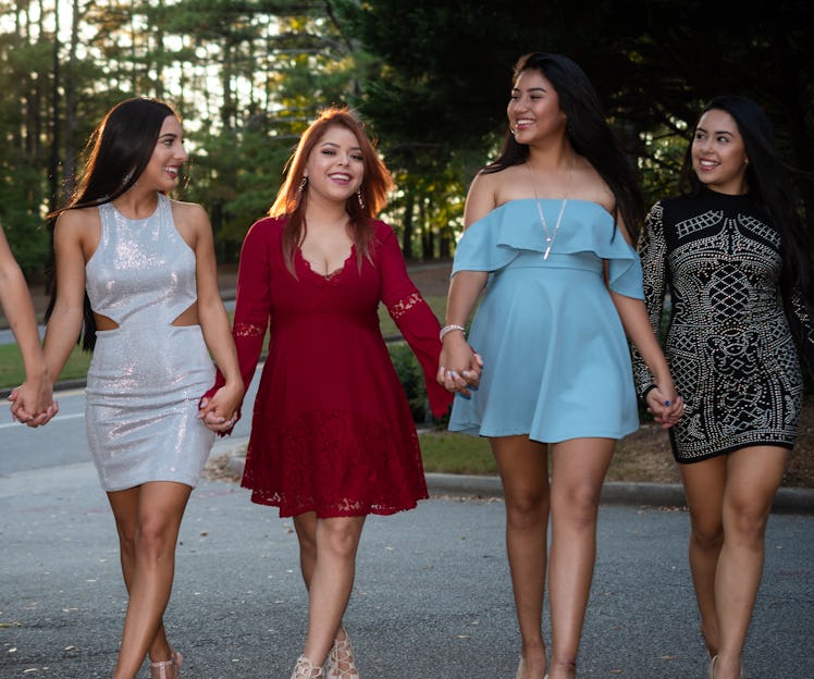 Sorority sisters walk hand in hand for a picture before their sorority formal, which they'll need In...