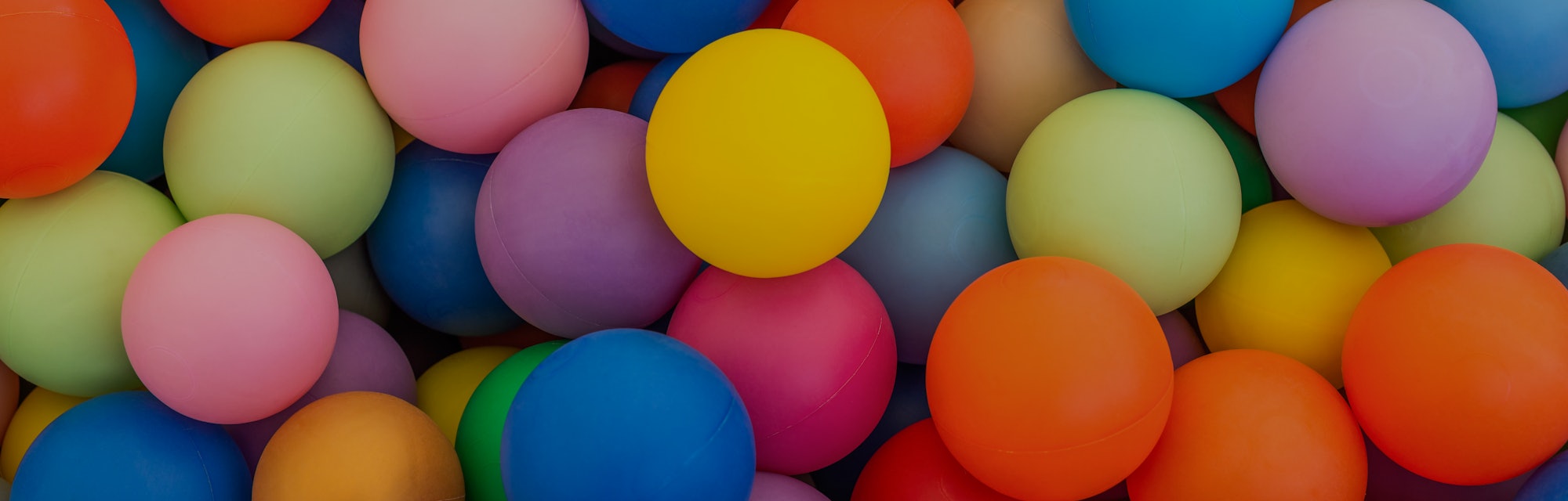 Full frame of multicolored plastic balls in the ball pit (ball crawl). Lots of colorful balls for ch...