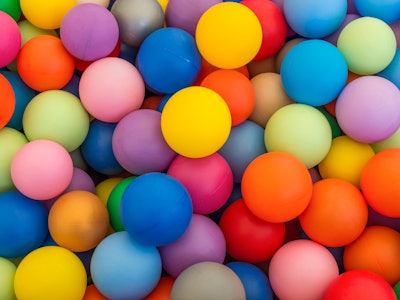 Full frame of multicolored plastic balls in the ball pit (ball crawl). Lots of colorful balls for ch...