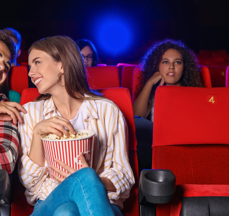 Couple with popcorn watching movie in cinema